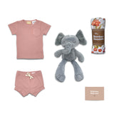 Baby clothing set with pink shirt and shorts, gray elephant toy, and bamboo swaddle on a white background.